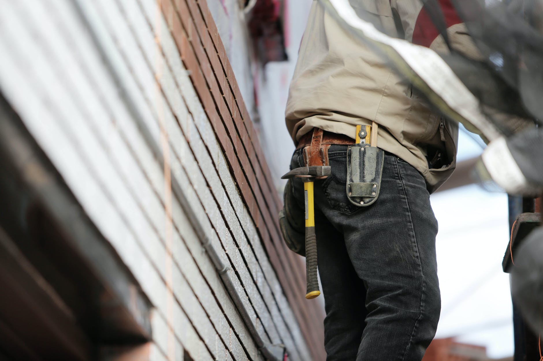 man wearing black denim pants with carrying hammer on holster